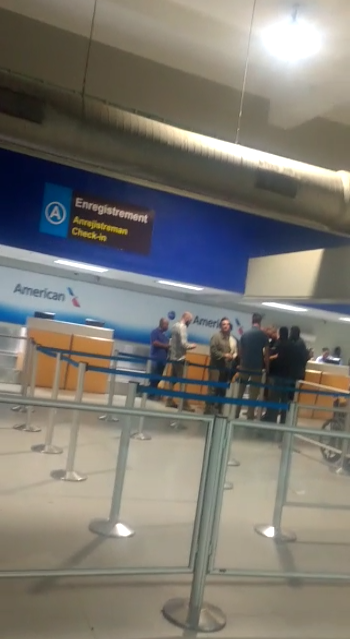 US embassy personnel escort American contractors through the American Airlines ticket counter.